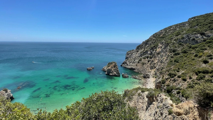 a large body of water sitting on top of a lush green hillside, pexels contest winner, les nabis, mediterranean beach background, shades of blue and grey, thumbnail, lisbon