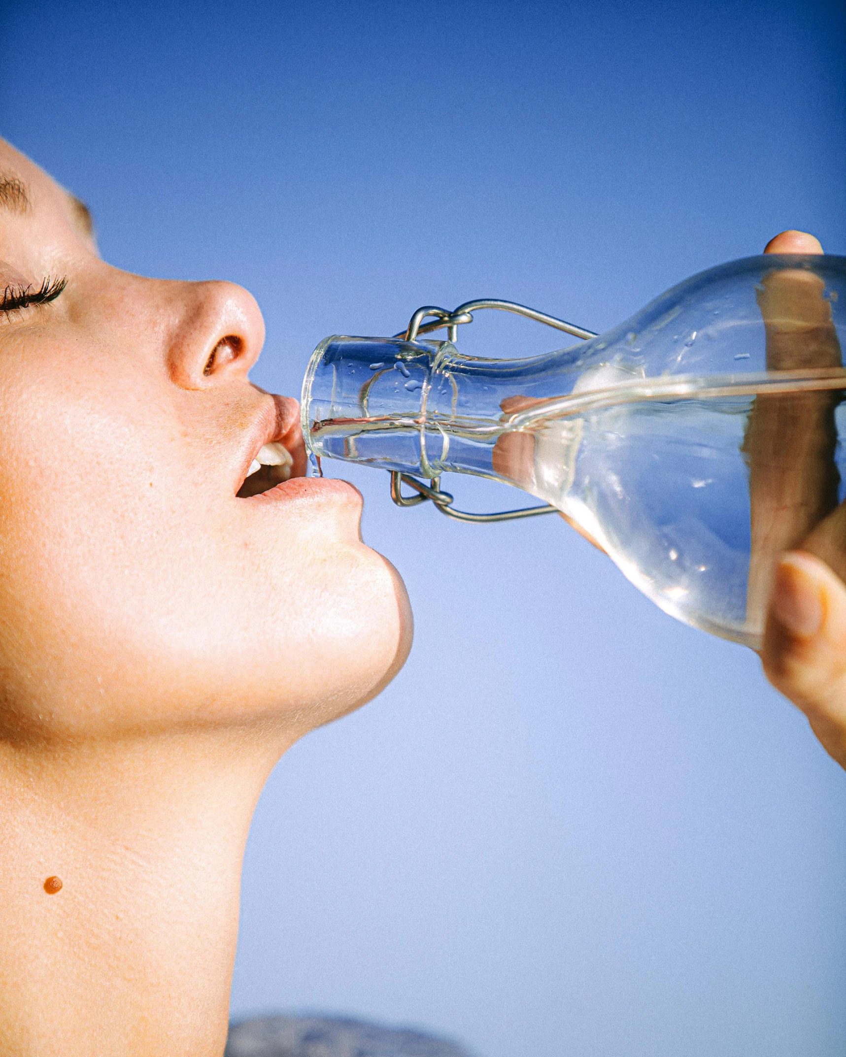 a woman drinking water out of a glass bottle, pexels contest winner, renaissance, clear facial details, on a hot australian day, lesbians, on clear background