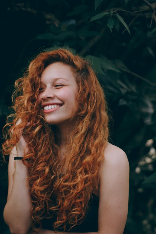 a woman with long red hair smiling at the camera, pexels contest winner, curly, profile image, smiling :: attractive, split near the left