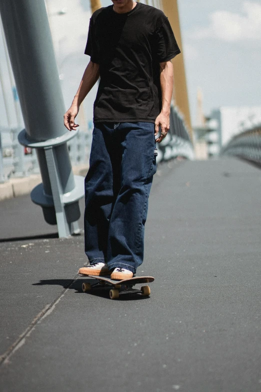 a man riding a skateboard across a bridge, a picture, baggy jeans, federation clothing, zoomed out full body, brown