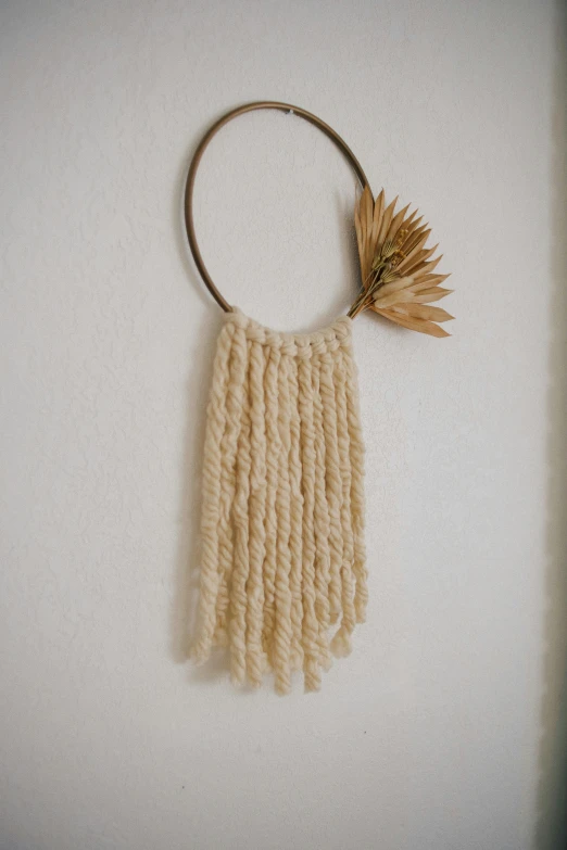 a close up of a piece of art on a wall, macrame, copper spiral hair decorations, dry grass, trending photo