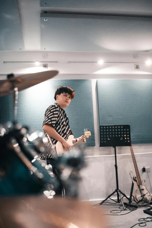 a man playing a guitar in a recording studio, an album cover, trending on unsplash, cai xukun, low quality photo, christian, schools