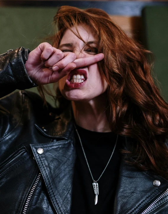 a close up of a person wearing a leather jacket, inspired by Elsa Bleda, trending on pexels, transgressive art, yelling, ( redhead, serpentine pose gesture, two fangs