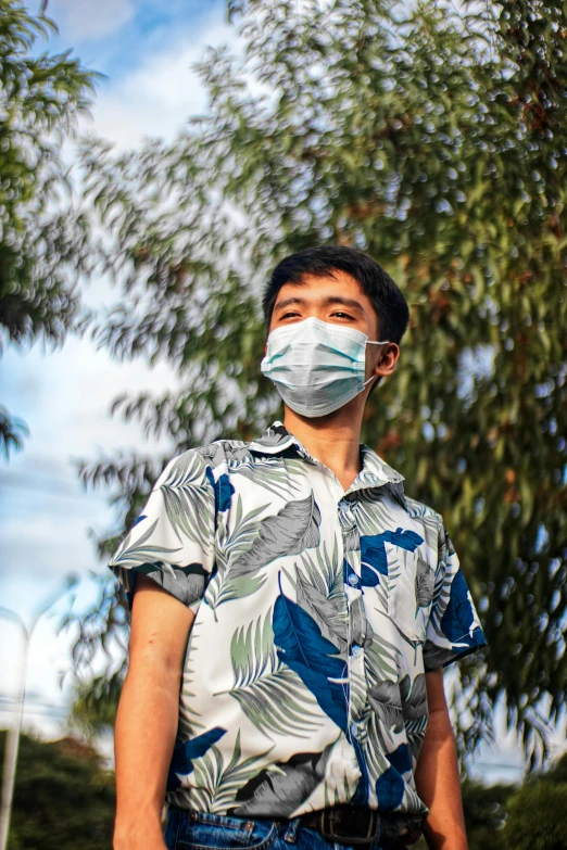 a man standing in front of a tree wearing a face mask, inspired by Liang Kai, wearing shirts, vapourwave, surgical mask covering mouth, with hawaiian shirt