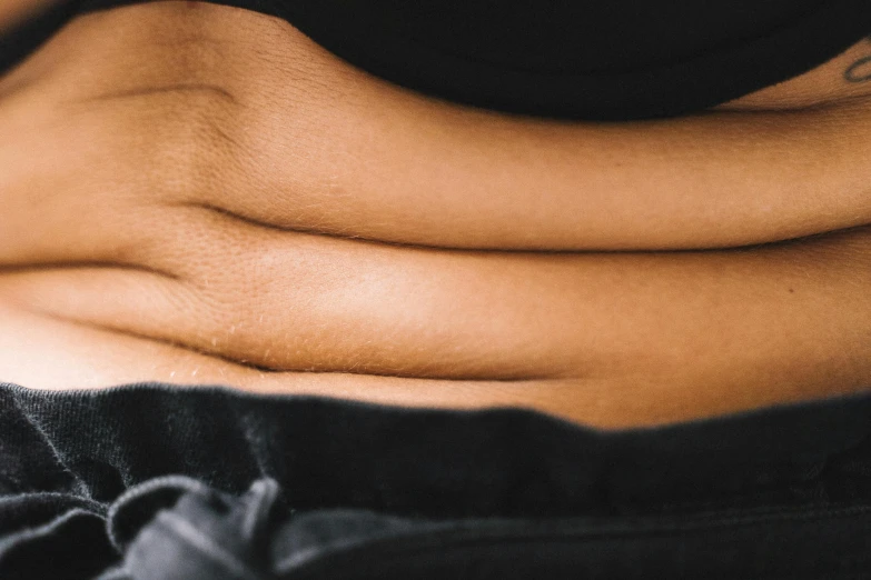 a woman with a tattoo on her stomach, trending on pexels, tight wrinkled cloath, inside a cavernous stomach, manuka, realistic »
