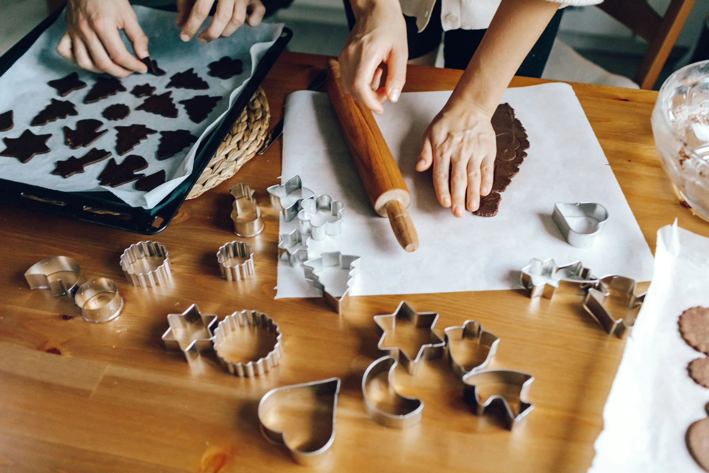 a couple of people are making cookies on a table, by Julia Pishtar, trending on pexels, arts and crafts movement, cut out, chocolate art, 9 9 designs