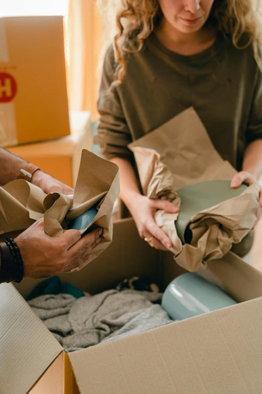 a man and woman unpacking boxes in a living room, pexels contest winner, renaissance, green and brown clothes, seams, thumbnail, ecommerce photograph