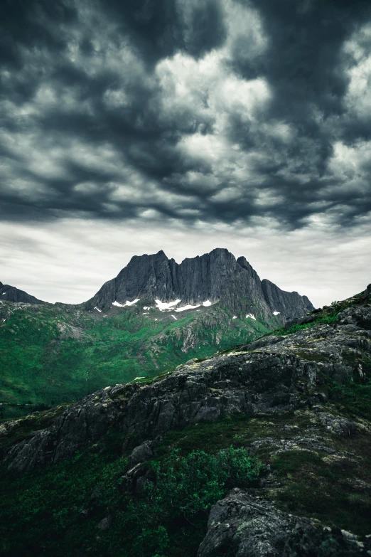 a view of a mountain range under a cloudy sky, an album cover, inspired by Oluf Høst, unsplash contest winner, looking threatening, minna sundberg, taken in the late 2010s, asgard