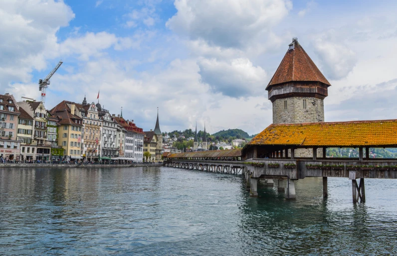 a bridge over a body of water with buildings in the background, by Karl Stauffer-Bern, pexels contest winner, renaissance, brutalist buildings tower over, turrets, a colorful, panoramic