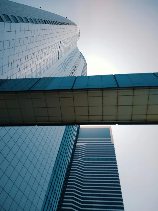 a couple of tall buildings next to each other, a picture, inspired by Cheng Jiasui, pexels contest winner, hypermodernism, low quality photo, photo on iphone, glass buildings, no watermarks