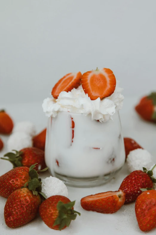 a glass of yogurt with strawberries on top, sea of parfait, detailed product image, whipped cream, angle view