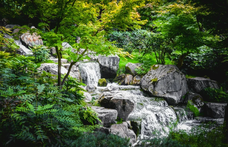 a waterfall running through a lush green forest, inspired by Sesshū Tōyō, pexels, gardens and fountains, rocks), grey, full colour