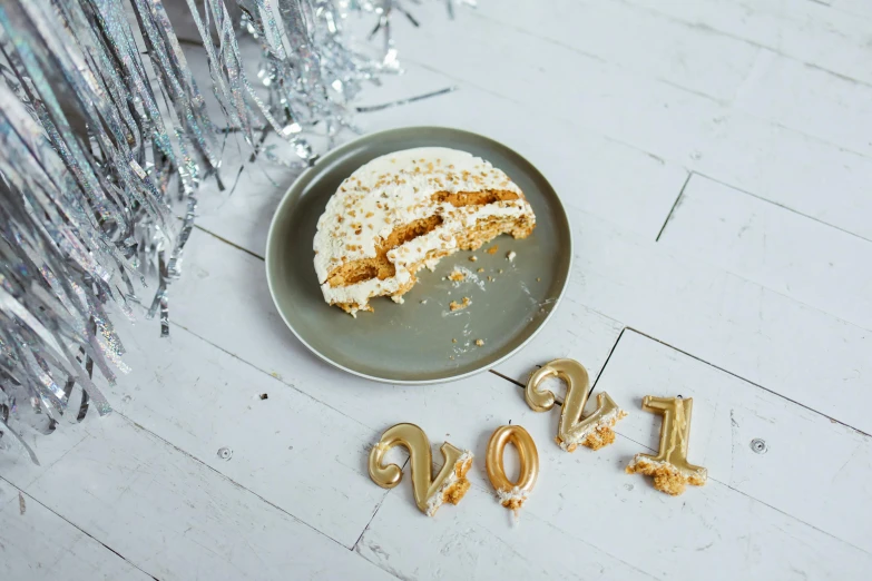 a plate that has a piece of cake on it, trending on pexels, happening, new years eve, golden number, cookies, covered in white flour