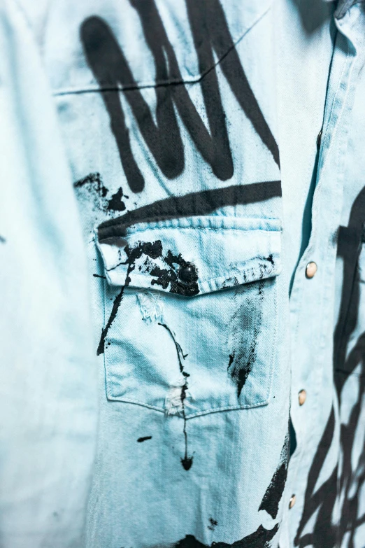 a close up of a shirt with graffiti on it, an album cover, trending on pexels, graffiti, lightblue acrylic paintdrip tar, detailed visible brushmarks, highly_detailded, pockets
