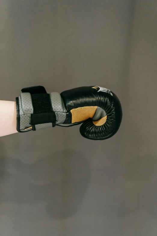 a person wearing a pair of boxing gloves, black and gold wires, scaled arm, godsent, center of image