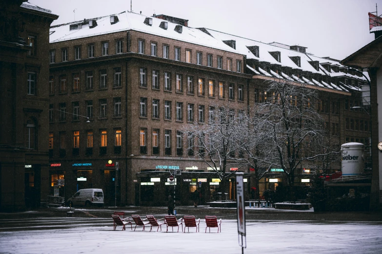 a group of red chairs sitting on top of a snow covered street, alvar aalto, empty streetscapes, hotel room, green square