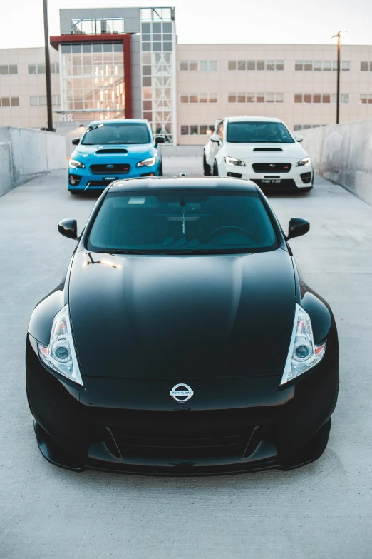 a black nissan sports car parked in a parking lot, by Matt Cavotta, pexels contest winner, the cars have faces, various colors, panoramic, instagram photo