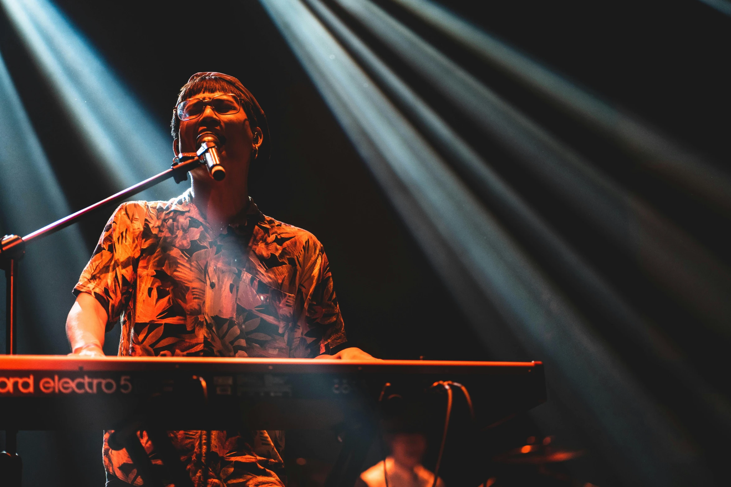 a man that is standing in front of a keyboard, an album cover, by Byron Galvez, unsplash, hurufiyya, performing on stage, sydney hanson, hozier, organs