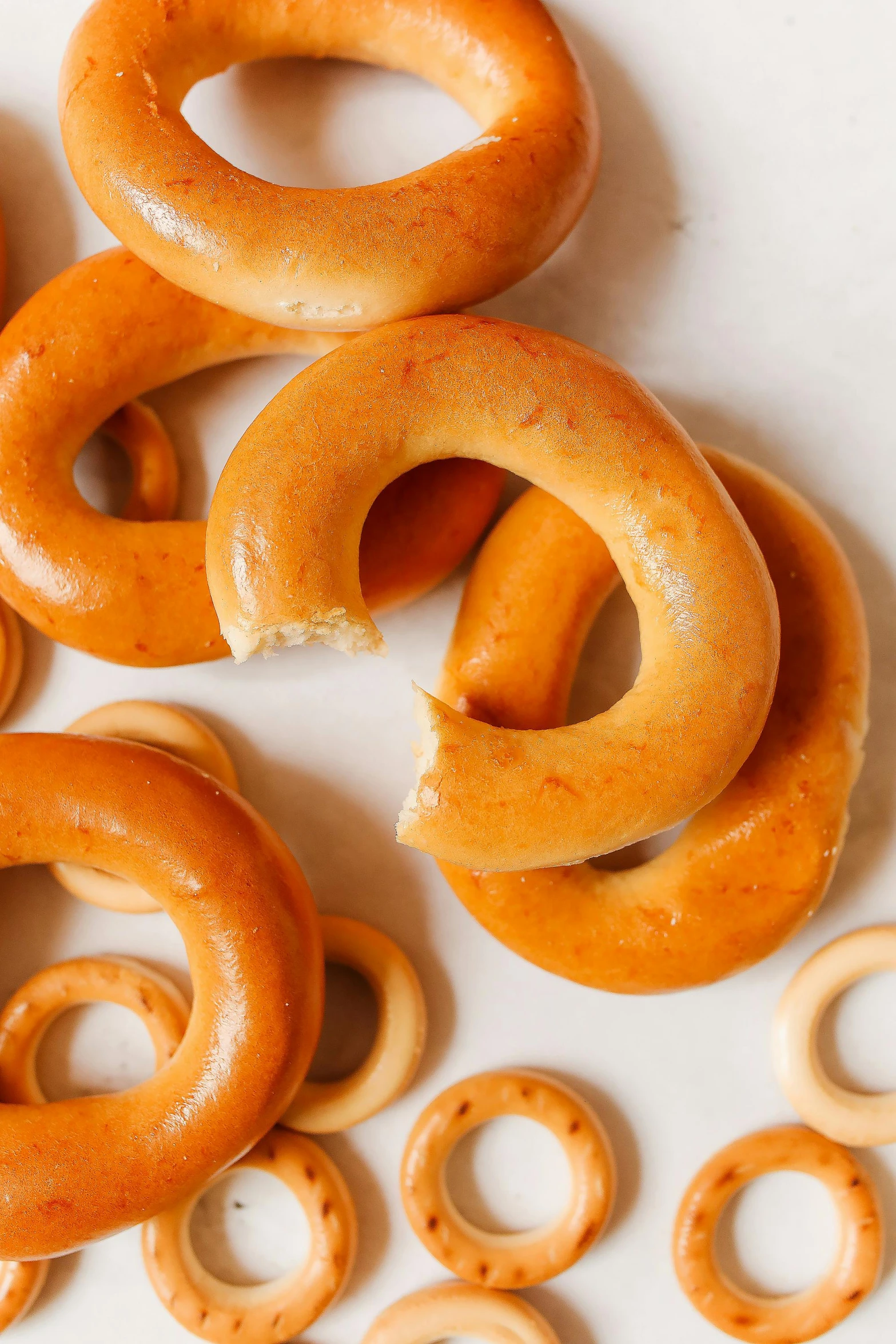 a pile of pretzels sitting on top of a table, yellow aureole, various sizes, smooth matte, no cropping