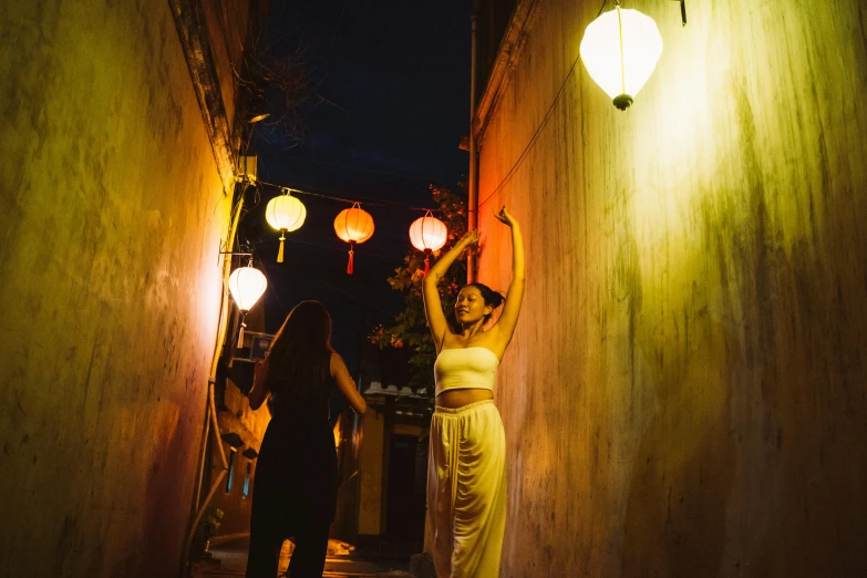a couple of women standing next to each other, a photo, pexels contest winner, happening, hanging lanterns, mai anh tran, dancing elegantly over you, promo image