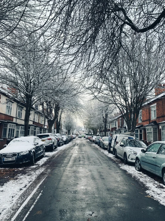 a street lined with parked cars covered in snow, inspired by Thomas Struth, pexels contest winner, ☁🌪🌙👩🏾, midlands, trees outside, paul davey
