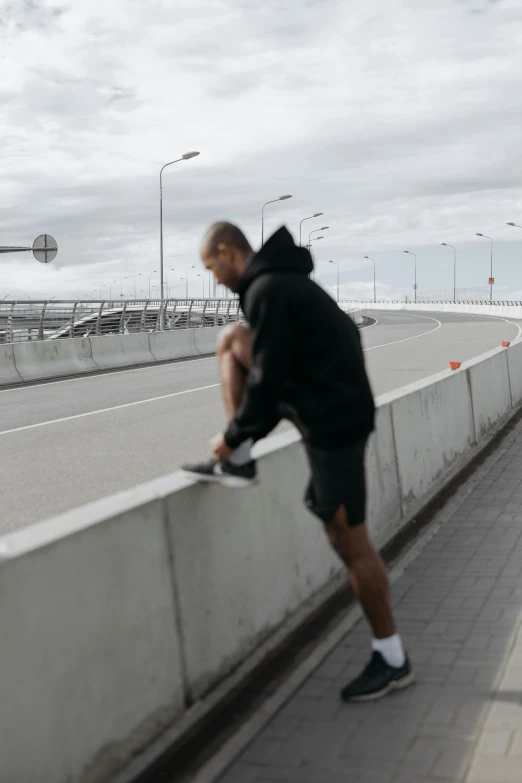 a man riding a skateboard down the side of a bridge, by Christen Dalsgaard, unsplash, happening, man in adidas tracksuit, gif, muscular thighs, gray shorts and black socks