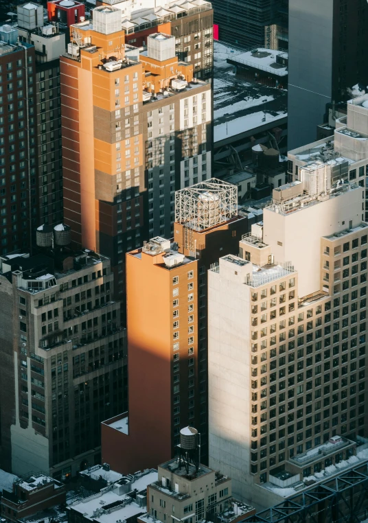 a group of tall buildings sitting next to each other, by Dan Christensen, pexels contest winner, modernism, orange roof, bird\'s eye view, new york buildings, high light on the left