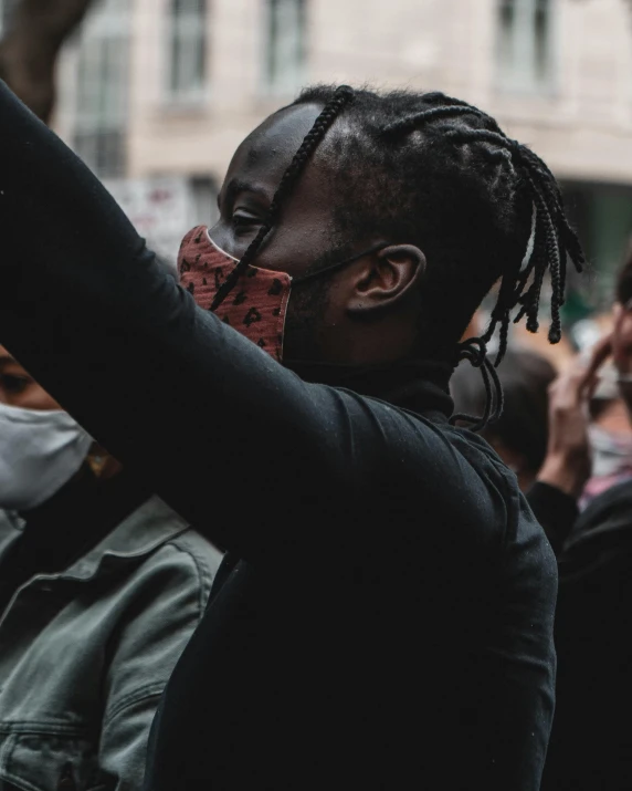 a person taking a picture with a cell phone, trending on pexels, black arts movement, pride month, man wearing a closed cowl, low quality photo, protest