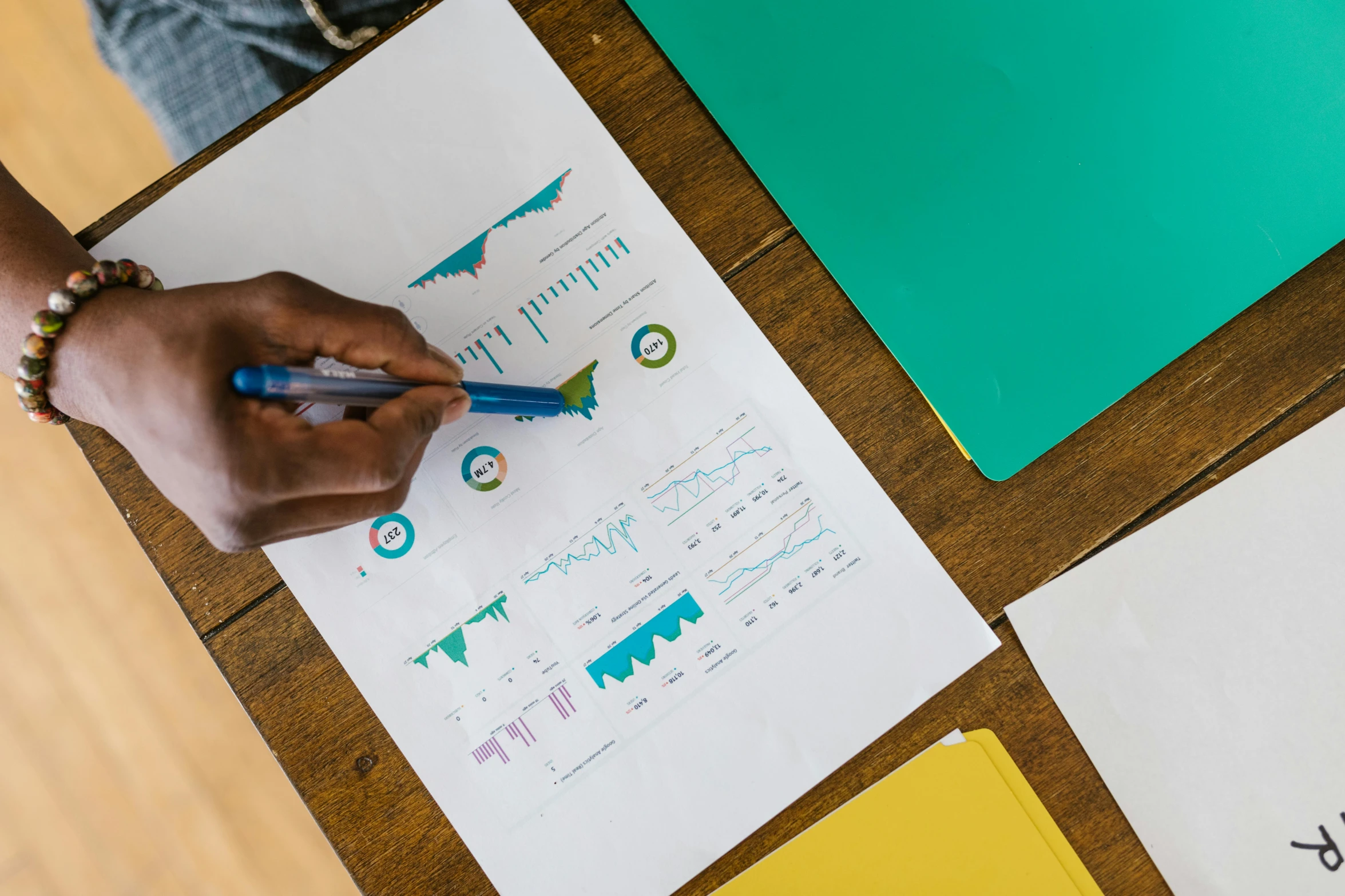 a person sitting at a table with papers and a pen, trending on unsplash, analytical art, gold and teal color scheme, with illustrations and diagrams, aida muluneh, school class