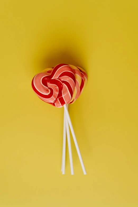 a heart shaped lollipop lollipop lollipop lollipop lollipop lollipop lollipop lollipop lo, a picture, inspired by Méret Oppenheim, unsplash, pop art, ribbons, scarlet and yellow scheme, photographed for reuters, made of lollypops