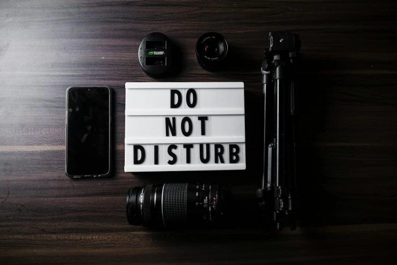 a sign that says don't disturb with a camera next to it, trending on pexels, avatar image, flatlay, disturbed, modest