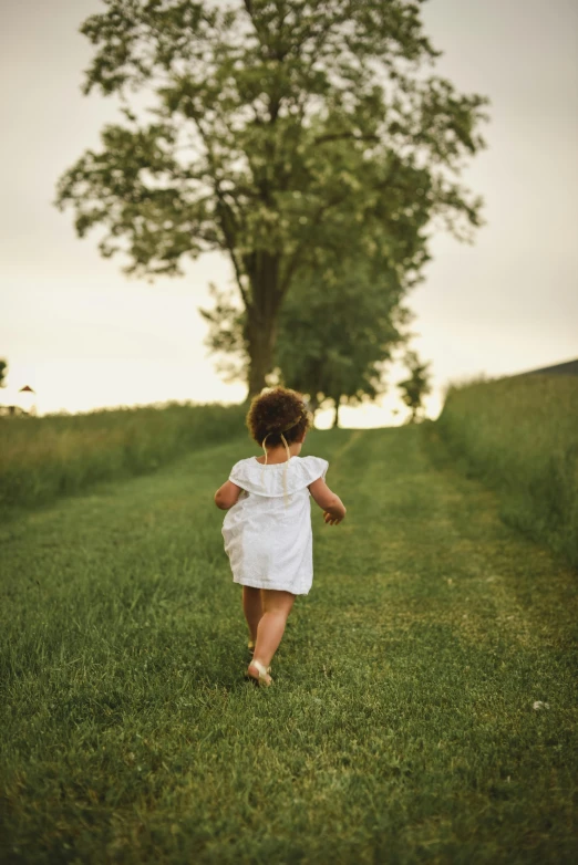 a little girl running in a field with a tree in the background, pexels contest winner, renaissance, white sundress, pathway, toddler, evening time