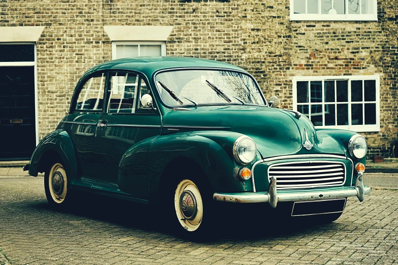 a green car parked in front of a brick building, by IAN SPRIGGS, pexels contest winner, vintage - w 1 0 2 4, front, old english, square