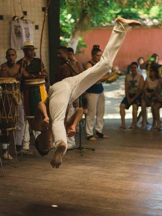 a man doing a handstand in front of a crowd, inspired by Francis Souza, happening, capoeira, beautiful surroundings, thumbnail, in sao paulo