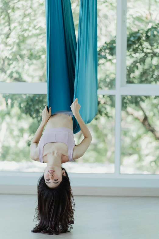 a woman doing a handstand in front of a window, inspired by Ren Hang, pexels contest winner, arabesque, floating. greenish blue, brunette fairy woman stretching, thailand, square