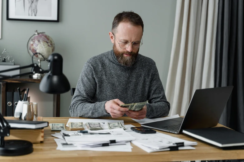 a man sitting at a desk with a laptop and a stack of money, pexels contest winner, doug walker, jovana rikalo, thumbnail, 1450