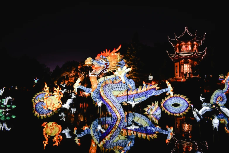 a group of dragon statues sitting on top of a body of water, during the night, avatar image