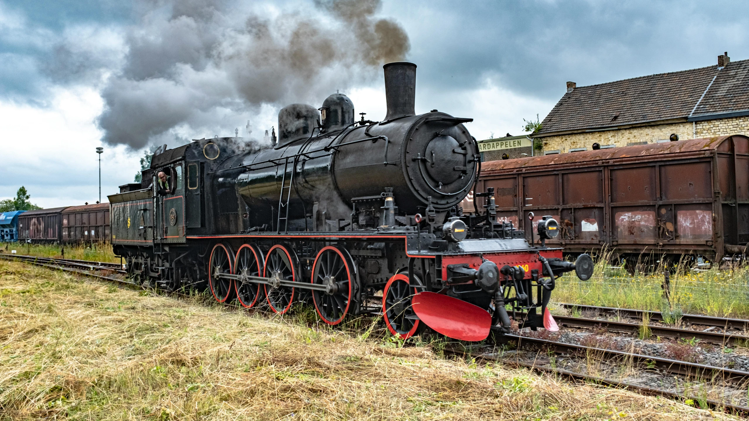 a train that is sitting on the tracks, pexels contest winner, a steam wheeler from 1880s, avatar image, 2263539546], black steel with red trim