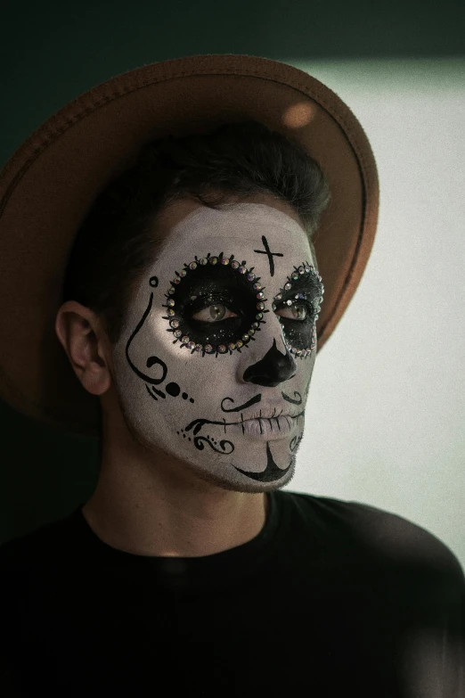 a man with a skull painted on his face, an album cover, inspired by Germán Londoño, pexels contest winner, square, lgbtq, sombrero, low quality photo