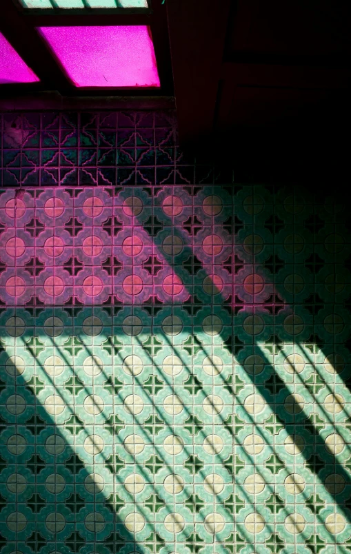 a bath room with a toilet and a window, a mosaic, inspired by Alberto Morrocco, unsplash, light and space, green magenta and gold, shadow of catholic church cross, pattern, shot on sony a 7