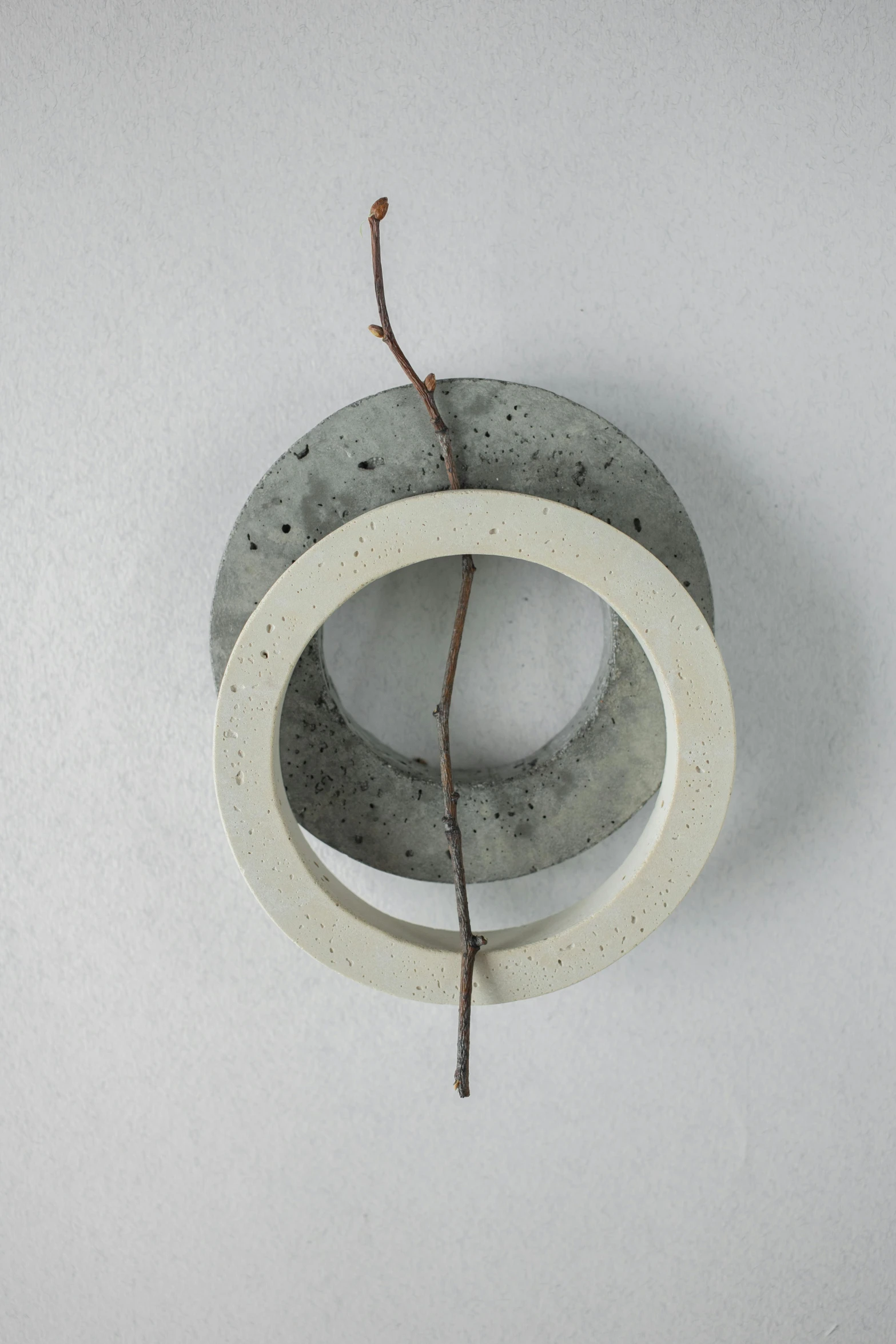 a close up of a concrete object on a wall, inspired by Frederik Vermehren, neck rings, ikebana, small, hanging