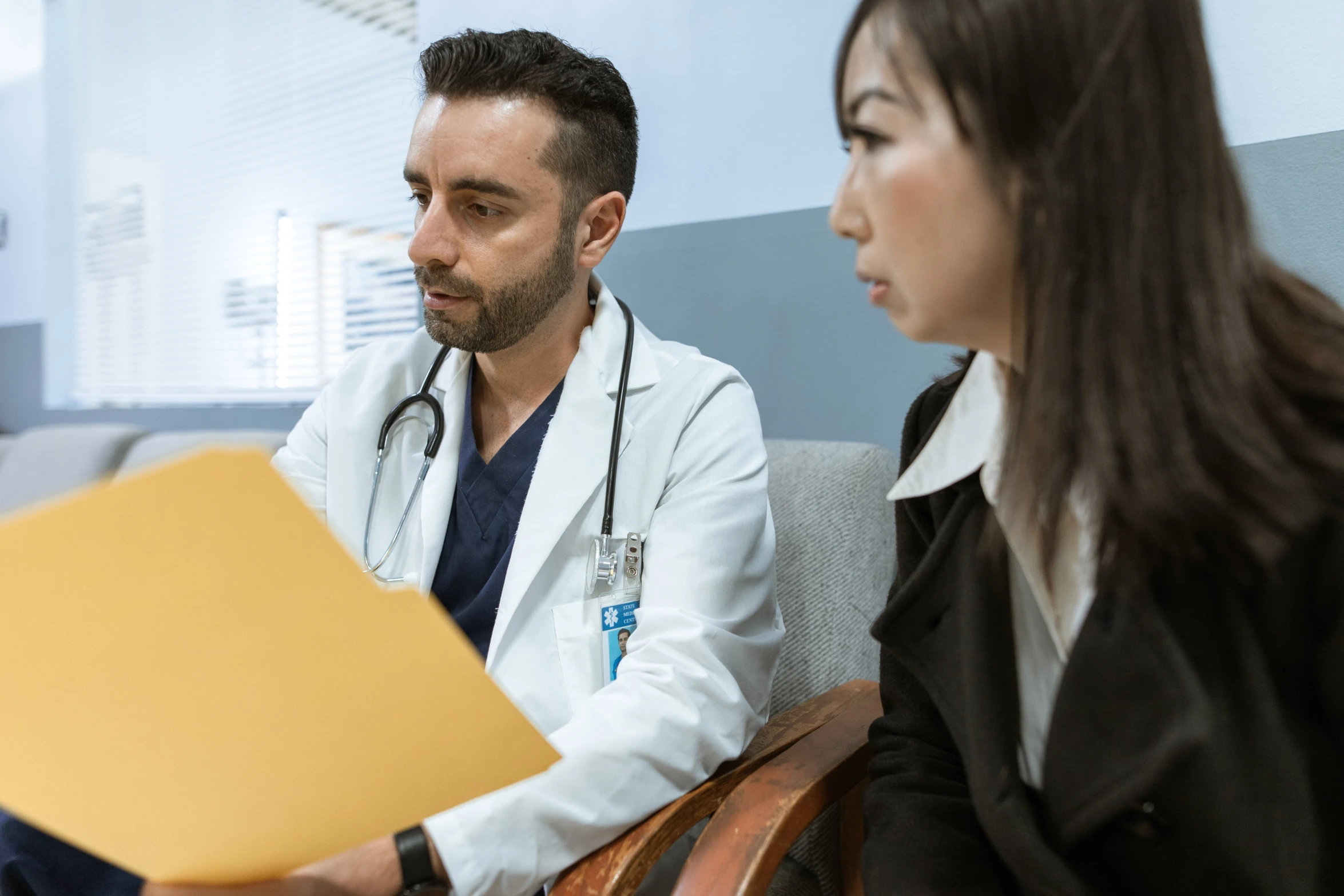 a man and a woman in a doctor's office, a colorized photo, pexels contest winner, profile image, lachlan bailey, center focus on table, document photo