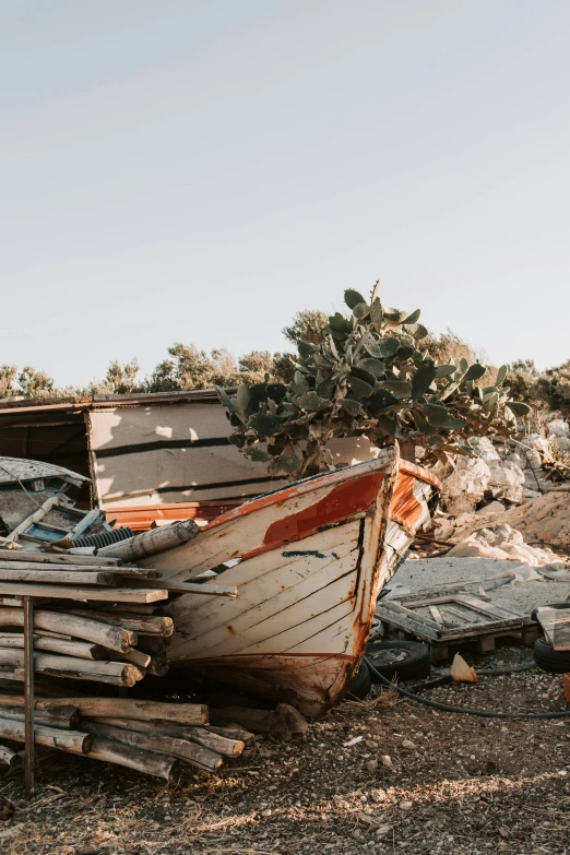 a boat sitting on top of a pile of wood, by Daniel Lieske, trending on unsplash, crumbled wall in jerusalem, small settlements, shipwrecks, debris on ground
