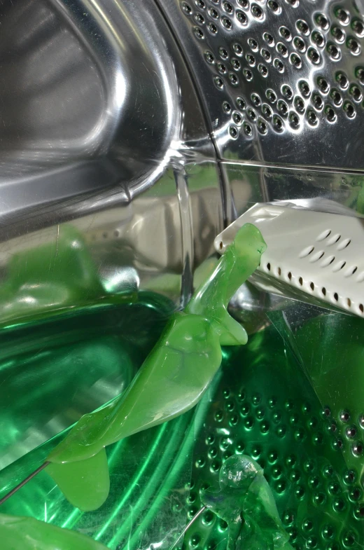 a close up of a green liquid in a washing machine, by Ben Zoeller, plasticien, mantis and swordfishes, promo image, soap, breeding