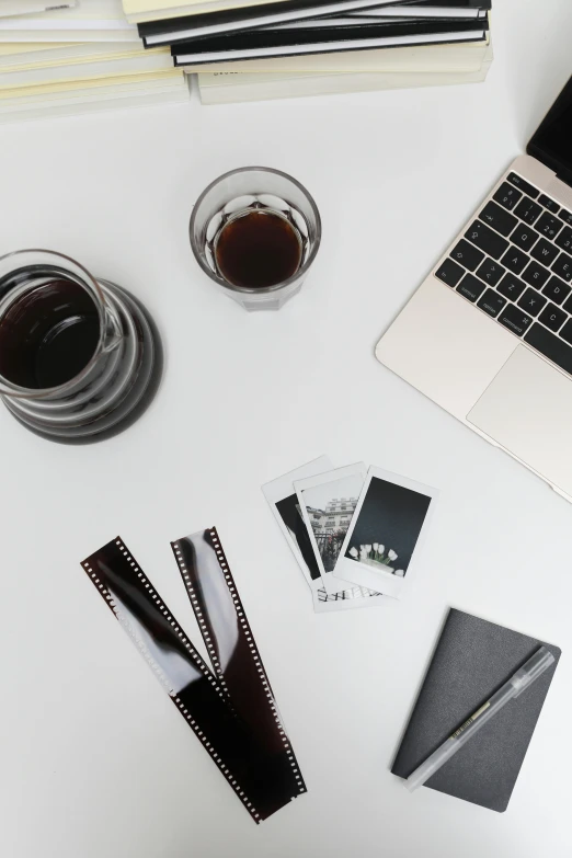 a laptop computer sitting on top of a white desk, a black and white photo, pexels contest winner, cold brew coffee ), shot of film, black and brown colors, set against a white background