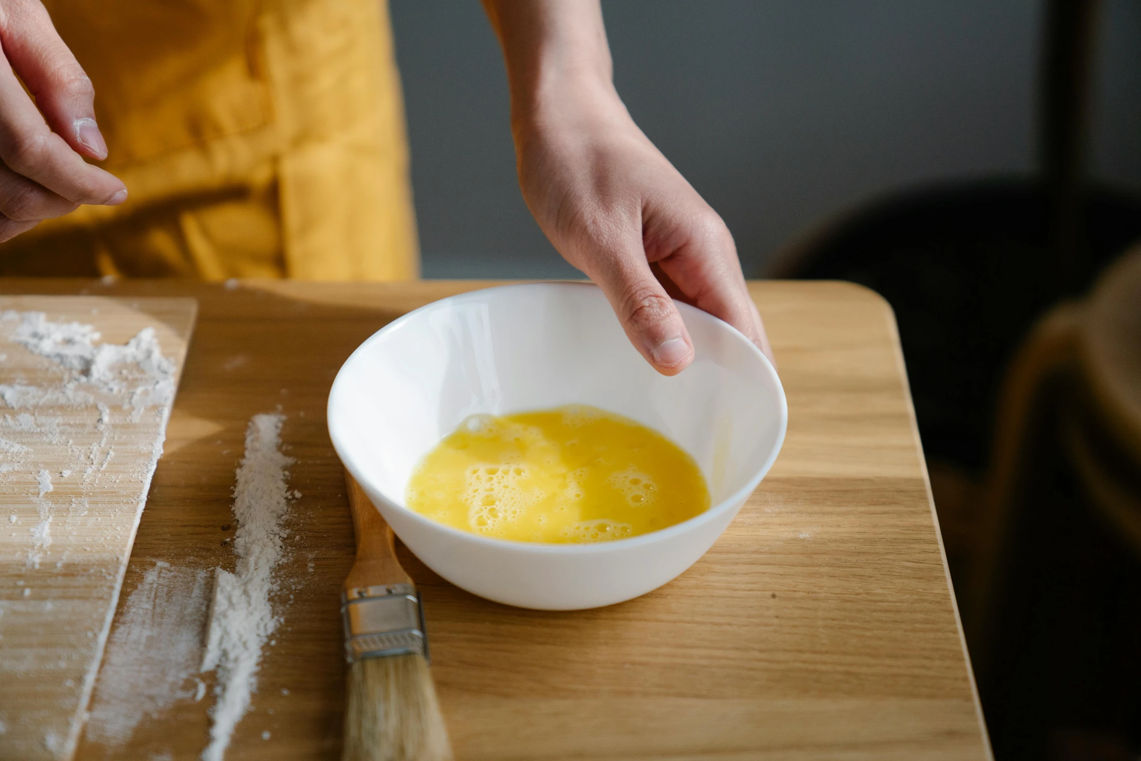 a person mixing eggs in a bowl on a table, inspired by Kanō Shōsenin, trending on pexels, baking french baguette, gloss finish, ceramic base, yellow