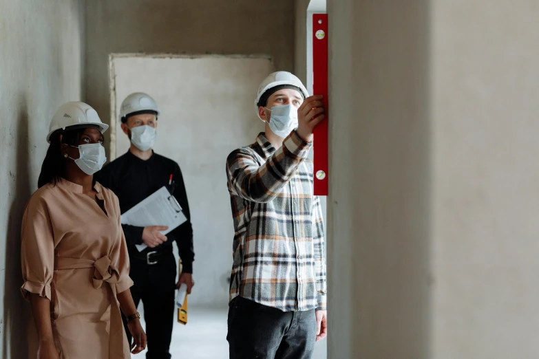 a group of construction workers standing next to each other, a photo, by Julia Pishtar, pexels contest winner, masked person in corner, inspect in inventory image, passive house, handsome man