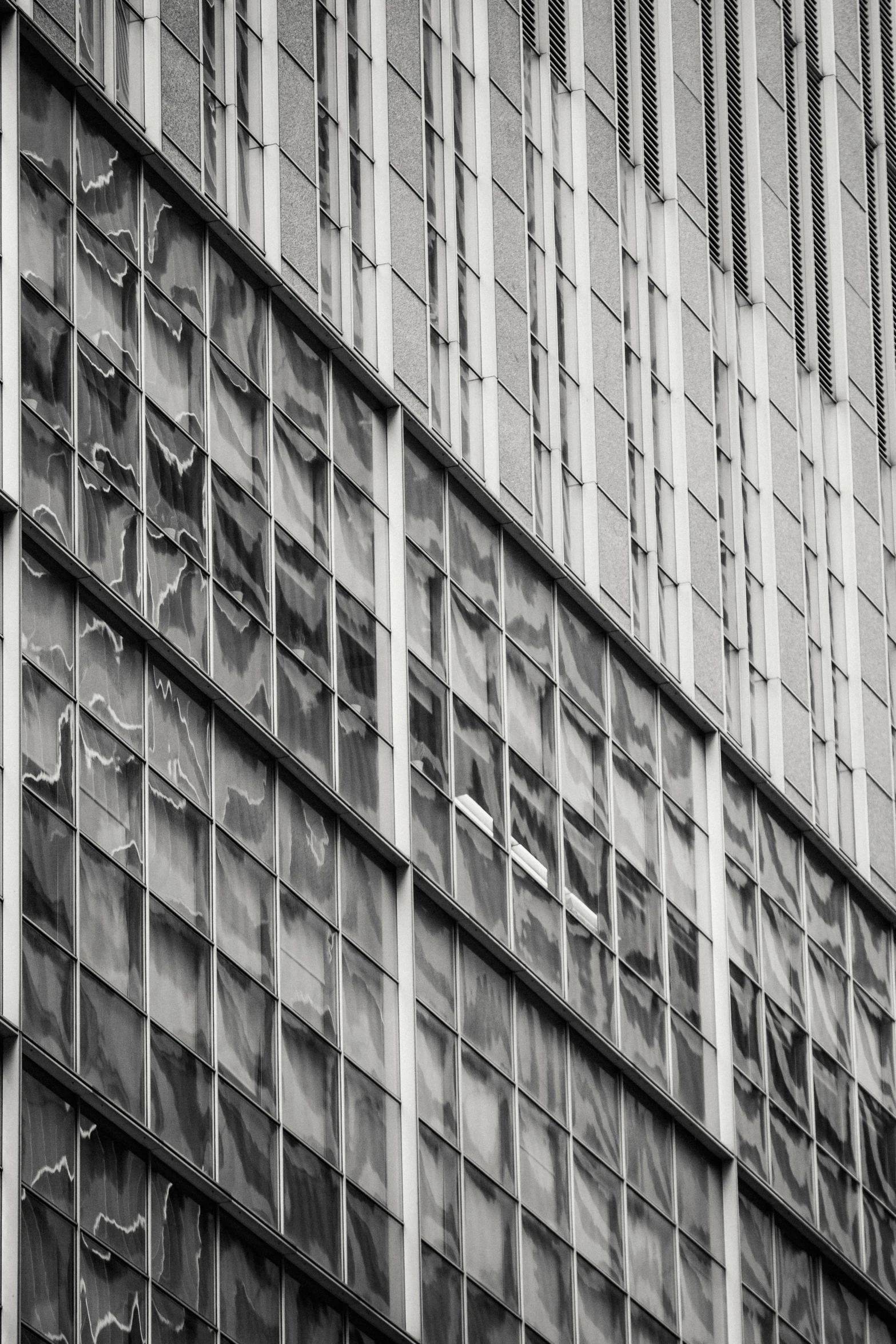 a black and white photo of a building, inspired by Vivian Maier, flickr, brutalism, broken glass photo, square shapes, full of glass. cgsociety, faded colors