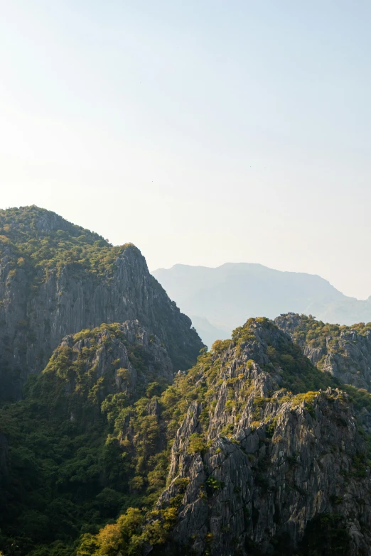 a group of people standing on top of a mountain, inspired by Li Keran, les nabis, seen from afar, limestone, skull island, kuang hong