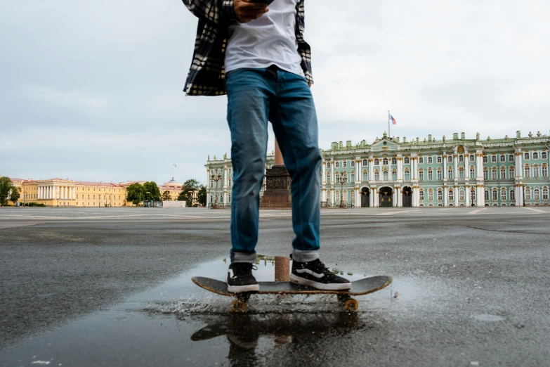 a man riding a skateboard across a puddle of water, by Julia Pishtar, pexels contest winner, kremlin, standing on a desk, jeans, 15081959 21121991 01012000 4k